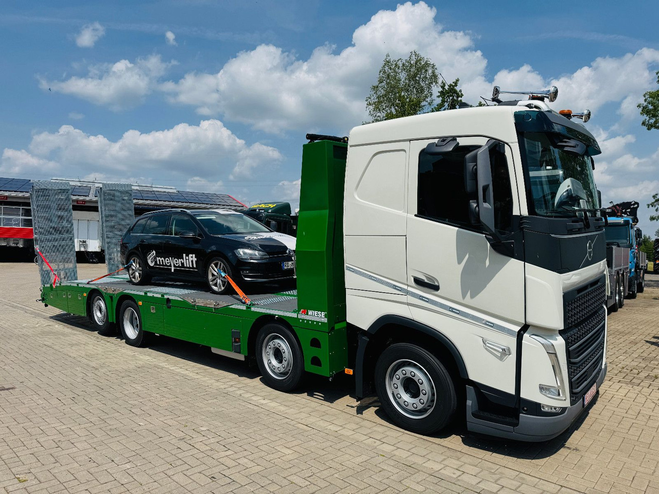 Volvo Arbeitsbühnen Baumaschinentransporter mit Rampen - Camião de caixa aberta/ Plataforma: foto 1 Volvo Arbeitsbühnen Baumaschinentransporter mit Rampen - Camião de caixa aberta/ Plataforma: foto 1